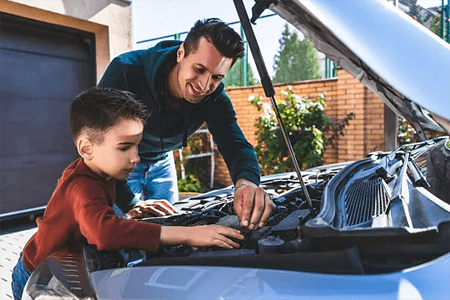 AutoPartsWAY customer working under the hood with a child